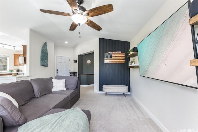 carpeted living room featuring track lighting and ceiling fan