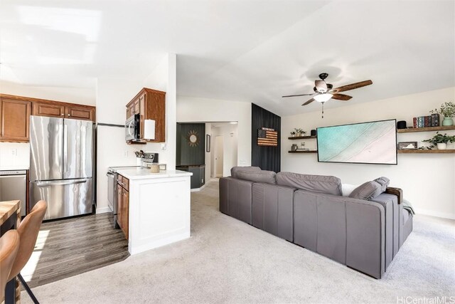 carpeted living room featuring vaulted ceiling and ceiling fan