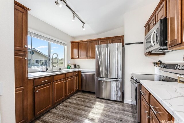 kitchen with sink, light stone countertops, dark hardwood / wood-style floors, and appliances with stainless steel finishes