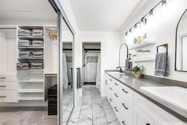 bathroom featuring vanity, toilet, and a tile shower