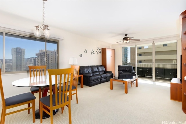 dining area featuring a wealth of natural light, carpet floors, and ceiling fan with notable chandelier