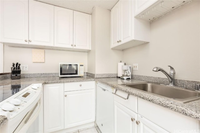 kitchen featuring light tile patterned floors, white appliances, white cabinetry, and sink