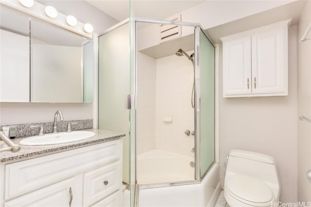 full bathroom featuring combined bath / shower with glass door, toilet, and vanity