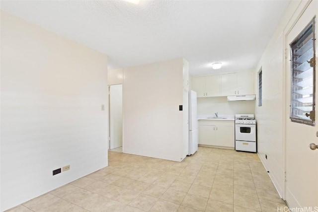 kitchen with a textured ceiling, white appliances, white cabinetry, and sink