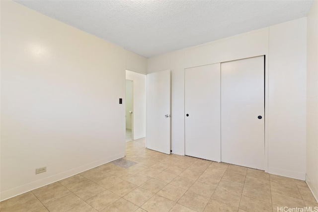 unfurnished bedroom featuring a textured ceiling and a closet