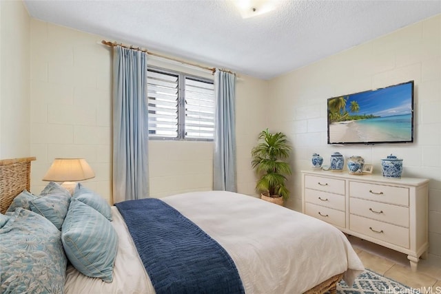 bedroom with light tile patterned flooring and a textured ceiling