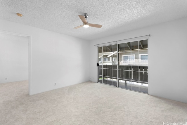 carpeted empty room featuring a textured ceiling and ceiling fan