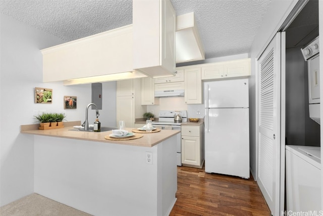 kitchen with stacked washer / dryer, sink, white appliances, and kitchen peninsula