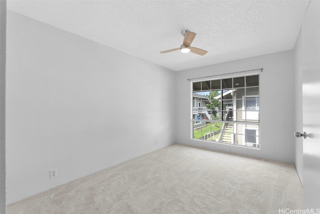 unfurnished room with ceiling fan, light carpet, and a textured ceiling