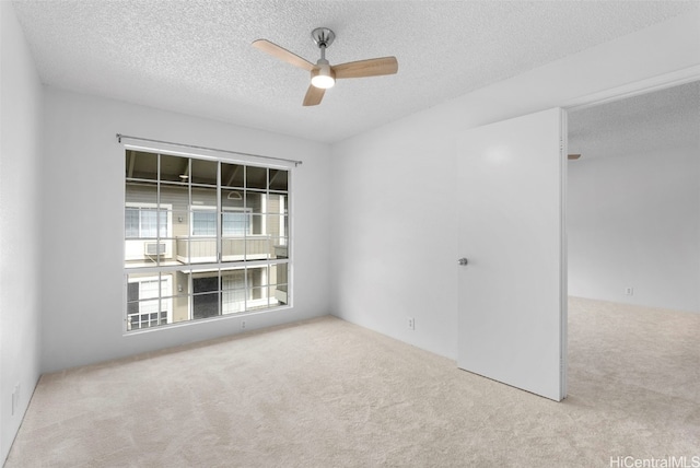 carpeted spare room with ceiling fan and a textured ceiling