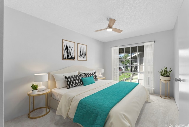 bedroom with ceiling fan, light carpet, and a textured ceiling