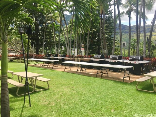 surrounding community featuring a mountain view and a lawn