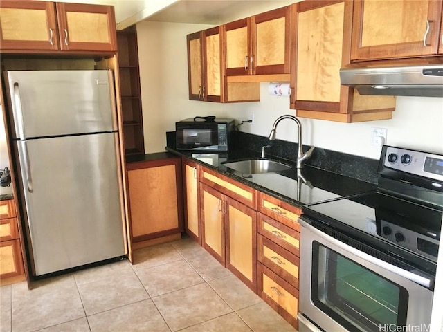 kitchen featuring light tile patterned flooring, sink, appliances with stainless steel finishes, and dark stone counters