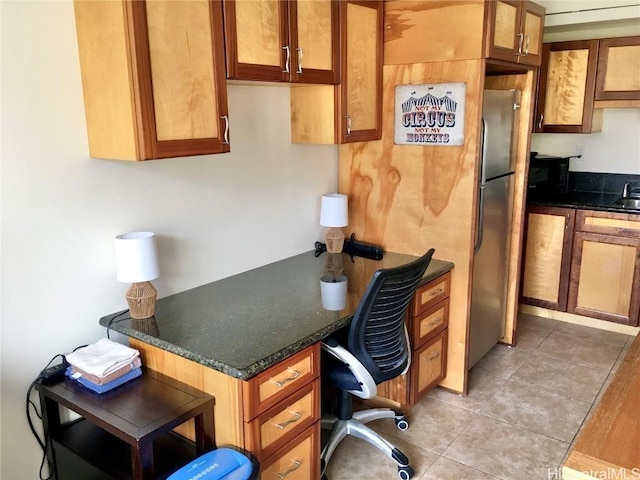 office area with light tile patterned floors and built in desk