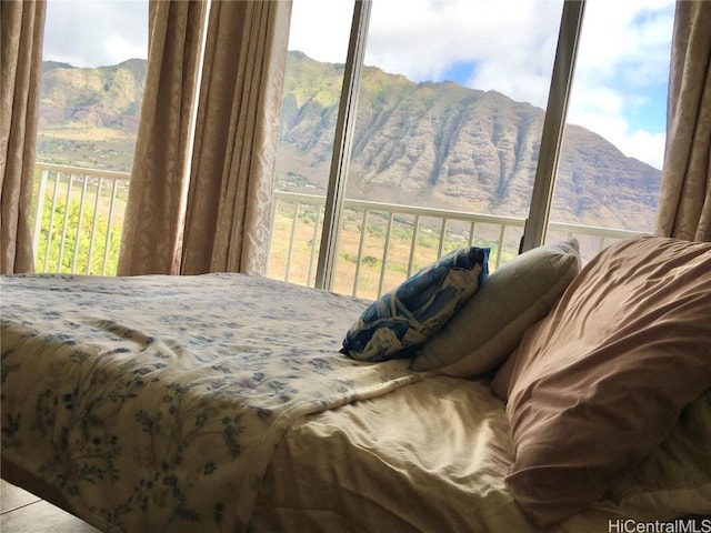 bedroom featuring a mountain view and multiple windows