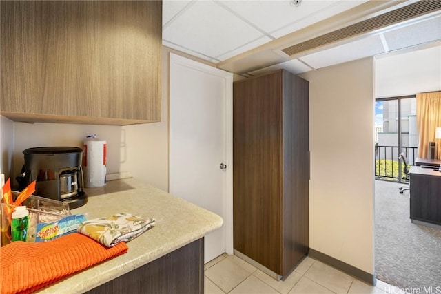 kitchen featuring a drop ceiling and light tile patterned floors