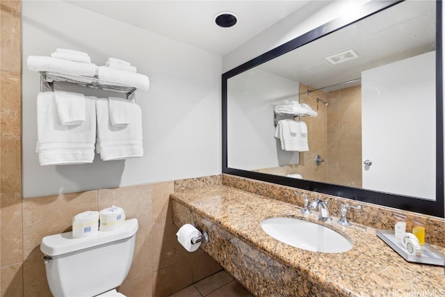 bathroom featuring tile patterned floors, sink, tile walls, and toilet