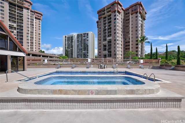 view of pool with a patio and a hot tub