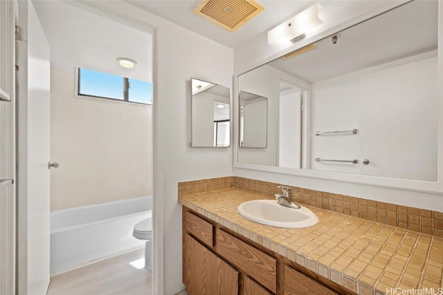 bathroom featuring toilet, vanity, and hardwood / wood-style flooring