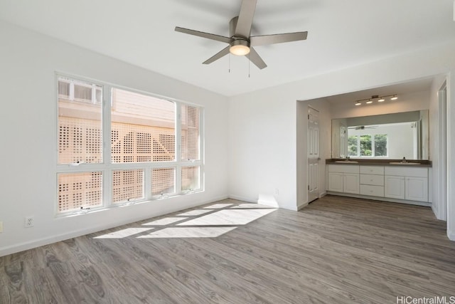 spare room with hardwood / wood-style floors, sink, and ceiling fan