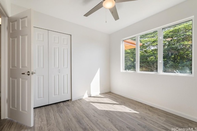 unfurnished bedroom featuring light hardwood / wood-style flooring, a closet, and ceiling fan