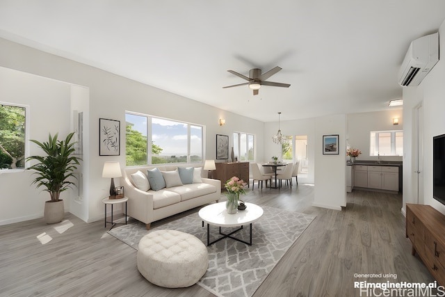 living room with a wall unit AC, ceiling fan, light hardwood / wood-style flooring, and plenty of natural light