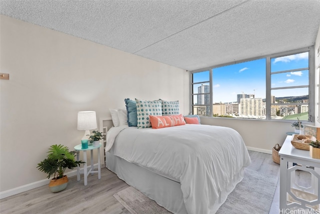 bedroom with light hardwood / wood-style floors and a textured ceiling