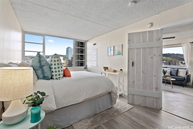 bedroom featuring a textured ceiling and light hardwood / wood-style flooring