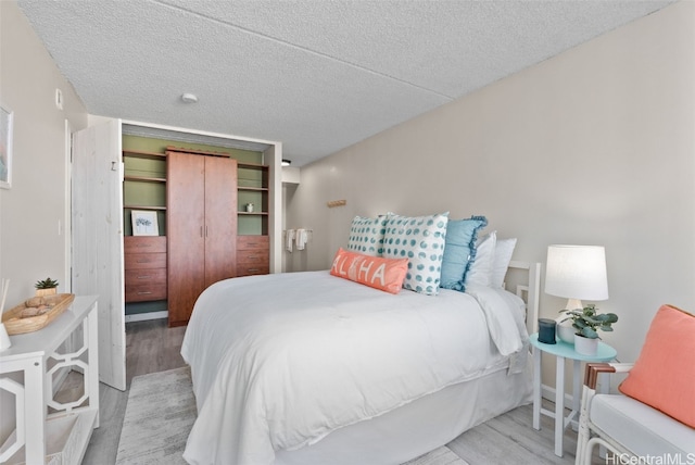 bedroom featuring a closet, a textured ceiling, and light wood-type flooring