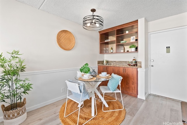 dining room featuring light hardwood / wood-style floors and a textured ceiling