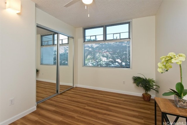 bedroom featuring multiple windows, hardwood / wood-style floors, and a textured ceiling