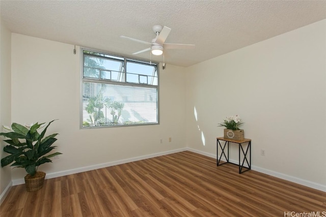 spare room with a textured ceiling, dark hardwood / wood-style flooring, and ceiling fan