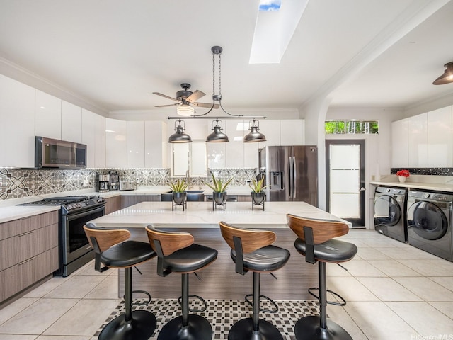 654 N Judd St Unit 654, Honolulu, HI 96817 - kitchen featuring stainless steel appliances, washing machine and clothes dryer, modern cabinets, and ornamental molding