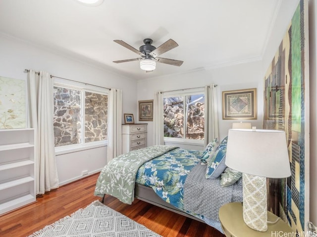 bedroom featuring ceiling fan, ornamental molding, and hardwood / wood-style flooring