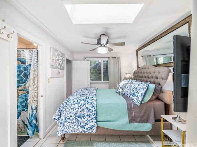 tiled bedroom featuring ceiling fan, crown molding, and a skylight