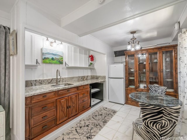 kitchen with white fridge, ornamental molding, and sink