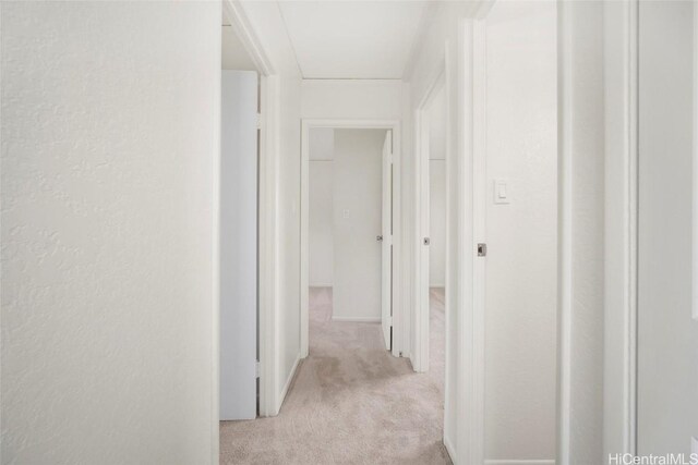 corridor featuring light colored carpet