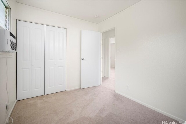 unfurnished bedroom featuring a closet and light colored carpet