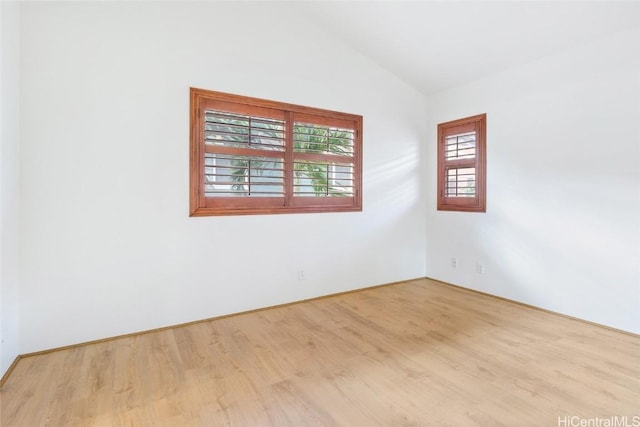 unfurnished room with light wood-type flooring and lofted ceiling