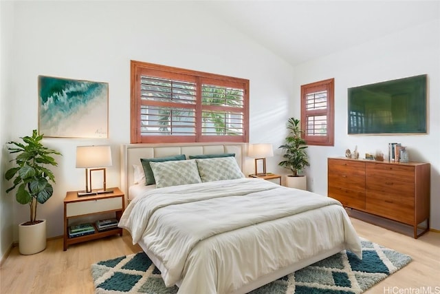 bedroom featuring light hardwood / wood-style flooring and lofted ceiling