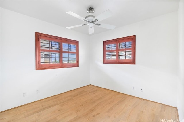 empty room with hardwood / wood-style floors and ceiling fan