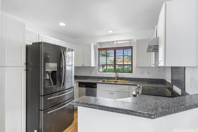 kitchen with kitchen peninsula, appliances with stainless steel finishes, sink, exhaust hood, and white cabinets