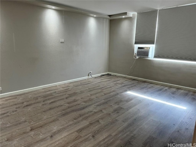 unfurnished room with cooling unit and hardwood / wood-style floors