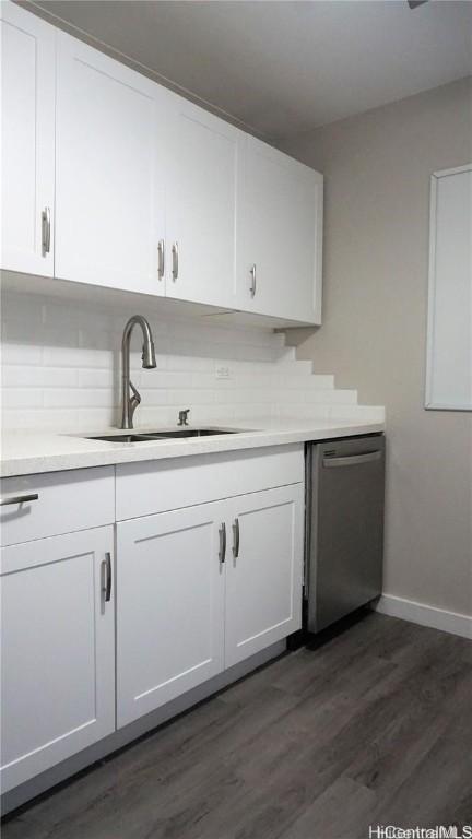 kitchen featuring dark wood-type flooring, stainless steel dishwasher, tasteful backsplash, white cabinetry, and sink