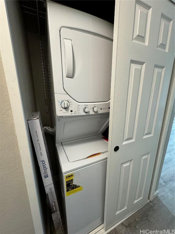 clothes washing area featuring stacked washing maching and dryer