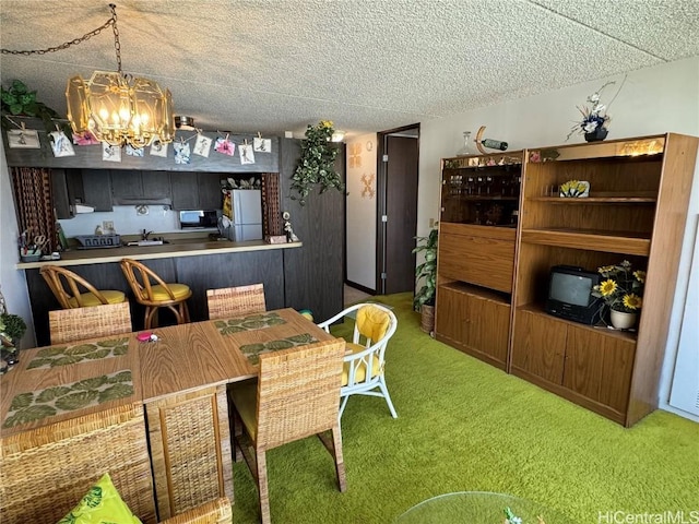 carpeted dining area with a textured ceiling and a notable chandelier