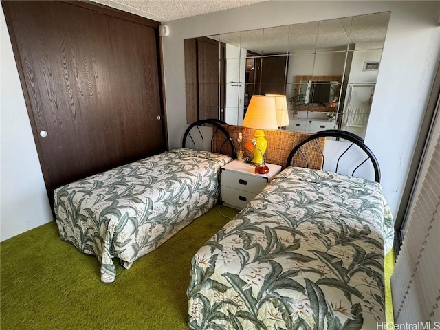 carpeted bedroom with a closet and a textured ceiling