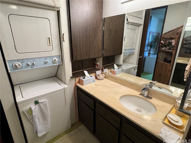 bathroom with vanity, stacked washer and clothes dryer, and toilet