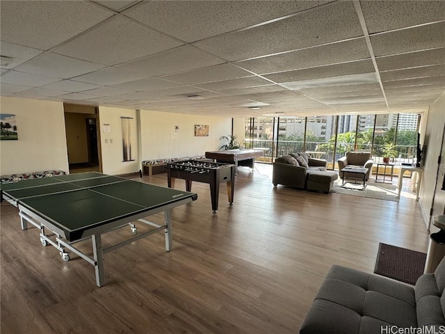 playroom featuring a drop ceiling, wood-type flooring, and a wall of windows