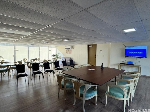 dining space featuring a wall unit AC, floor to ceiling windows, a paneled ceiling, and hardwood / wood-style flooring